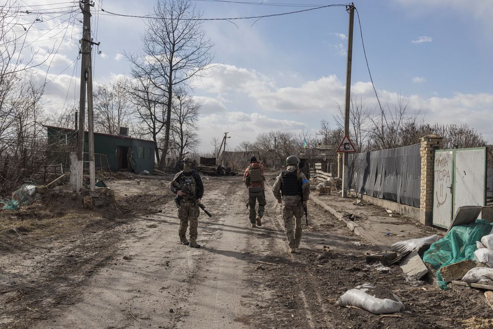 Ukrainian servicemen walking outside Kyiv