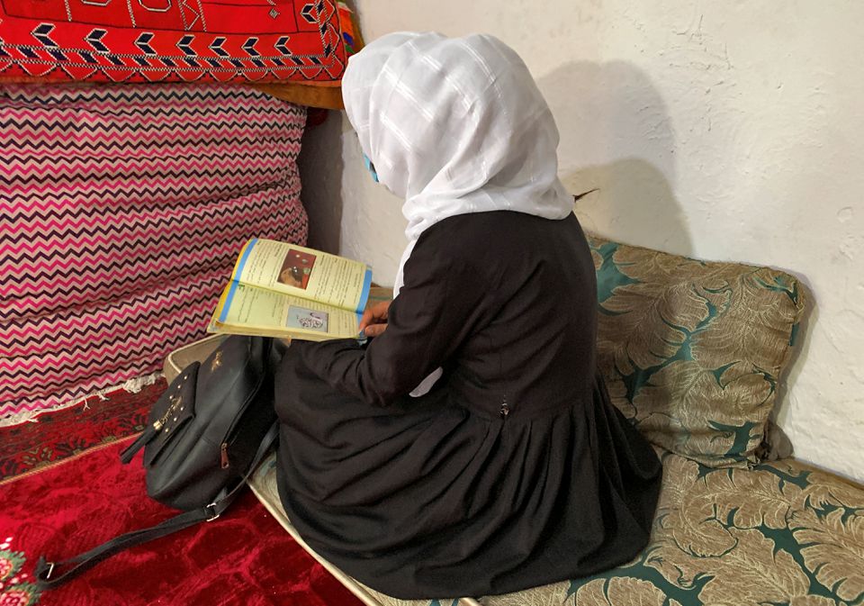 Afghan female student reading her book