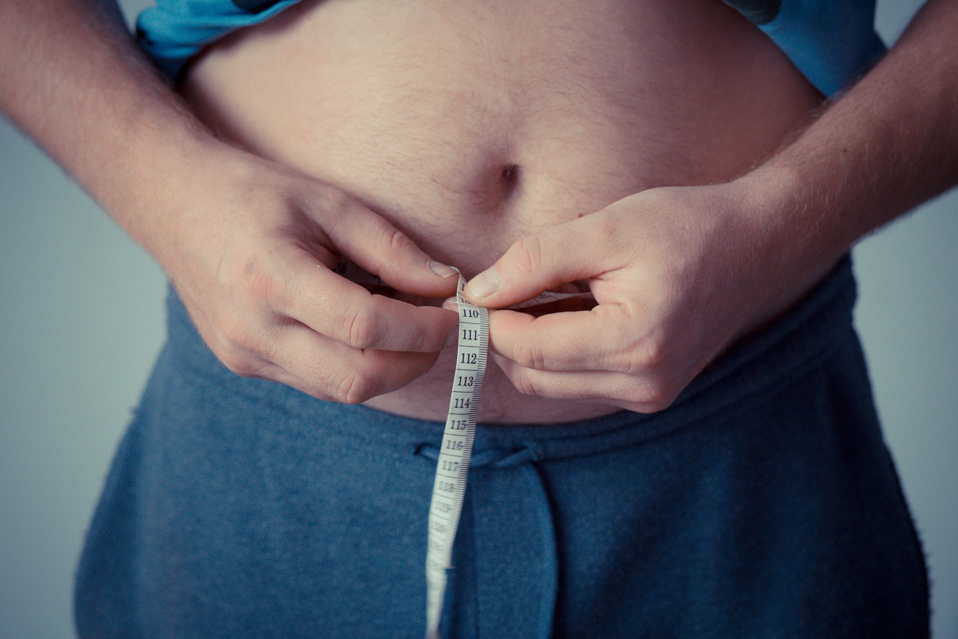 A person is measuring his waist