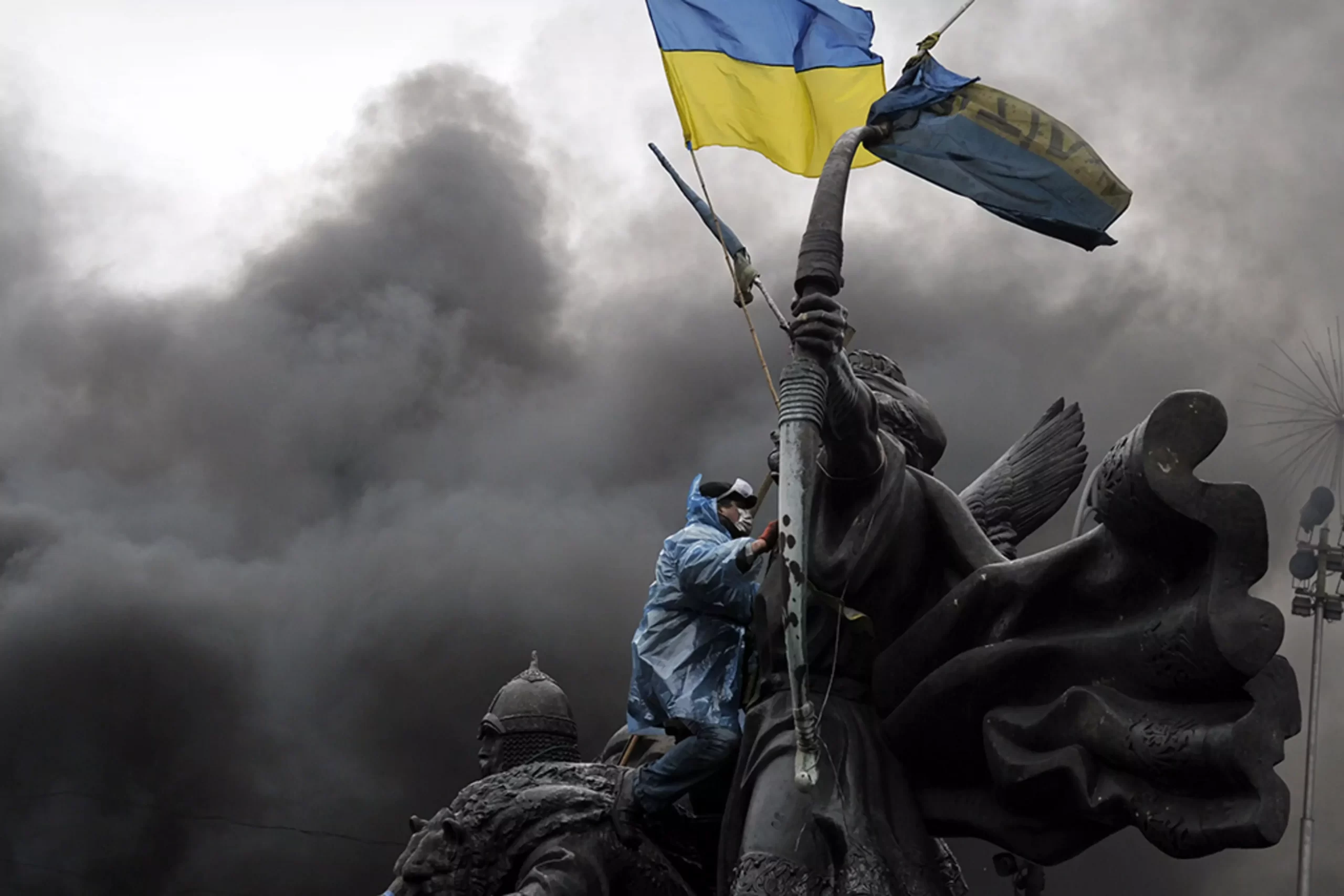 a protestor sitting on monument in Kyiv